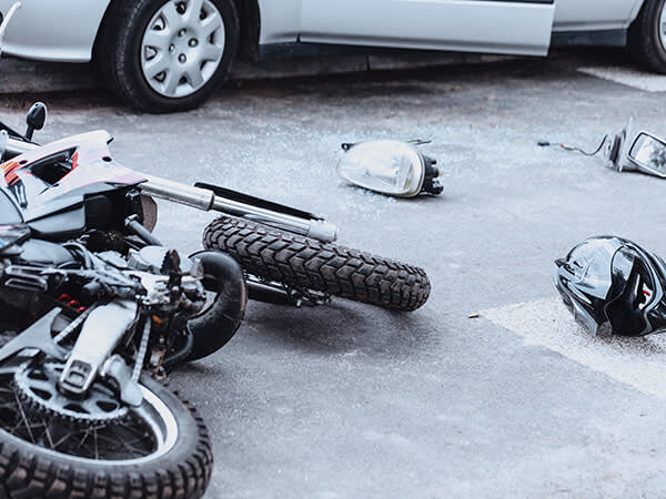 Crashed motorcycle near damaged car