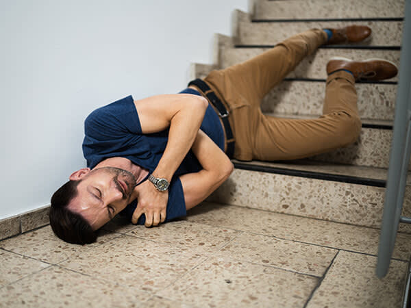 Man lying on the ground after falling down the stairs