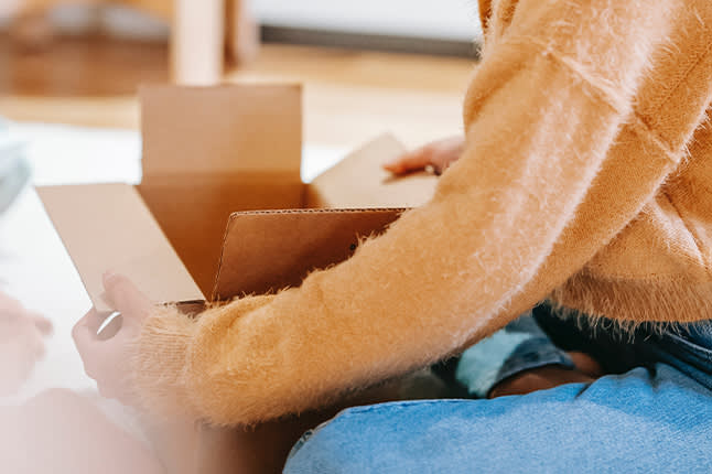 Woman packing with a cardboard box