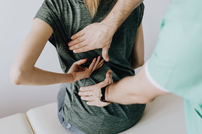 Doctor examining a woman's back injury