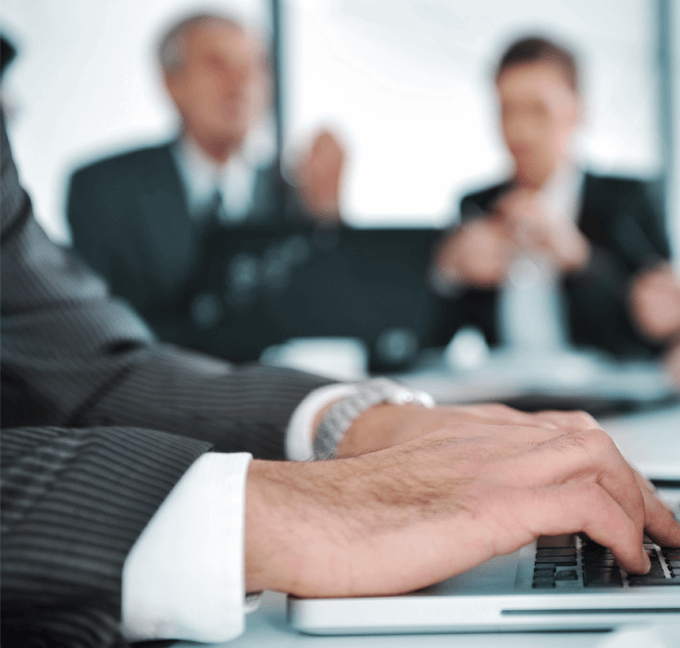 Person in suit typing on laptop