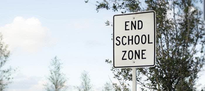 "End School Zone" black and white sign outside