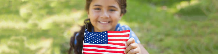 Girl smiling and holding a little American flag