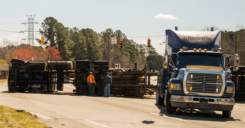 Semi truck overturned and two men standing by