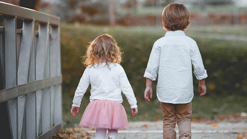 Young children walking on a bridge outside