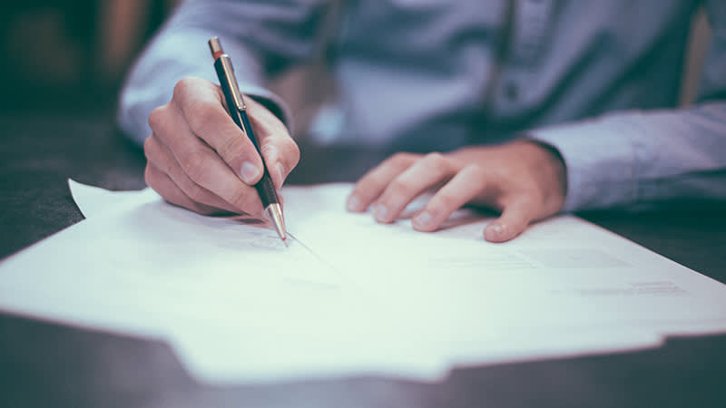 Close up of man filling out paperwork
