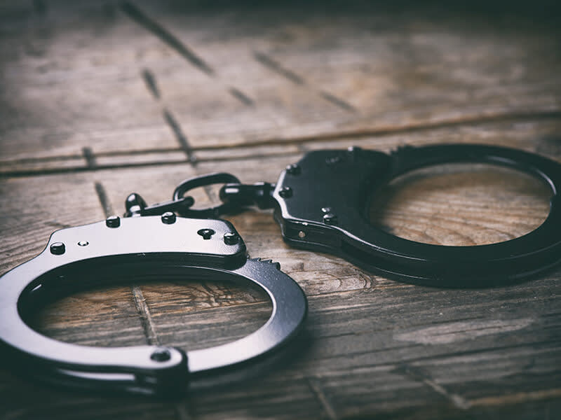 Handcuffs on wooden background