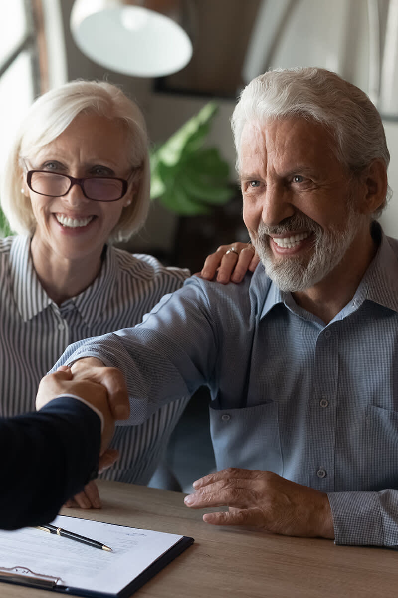 Couple shaking hands with a businessman