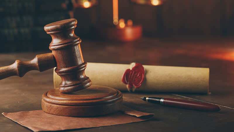 Gavel, sealed document, envelope, and pen
