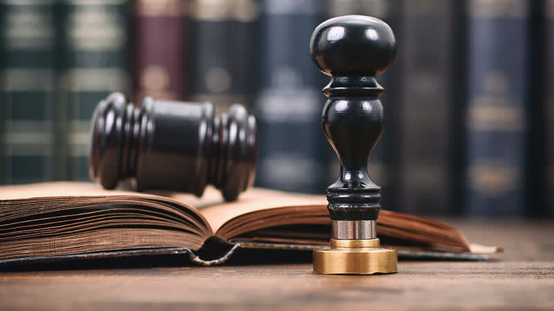 Gavel, open law book, and notary stamp