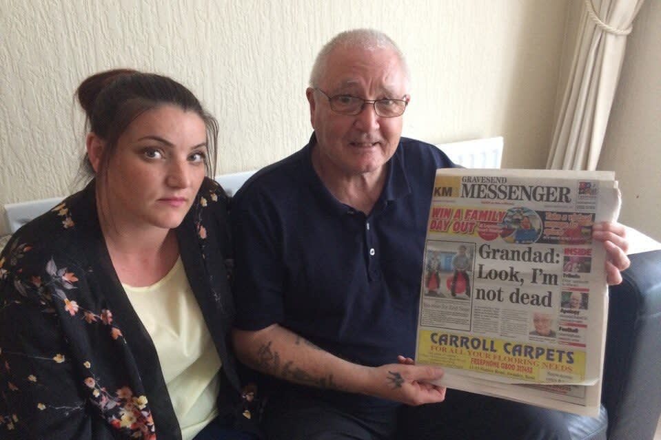 Man and woman holding up newspaper