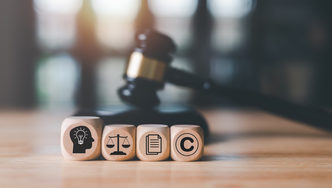 Wooden cube with icons related to intellectual property protection and gavel