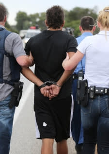 Cops escorting someone away in handcuffs