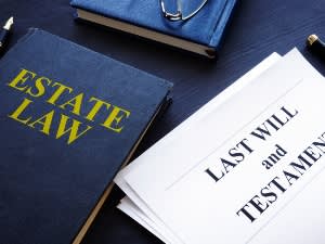 Books and documents that read "Estate Law" and "Last Will and Testament"