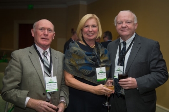 John Foley smiling with two people for picture