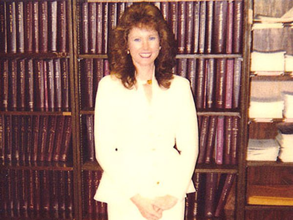 Vicky Collins in front of Bookshelf