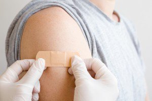 Nurse putting a band aide on a female patient