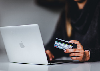 person sitting at computer with credit card