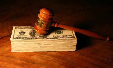 stack of money with a wooden gavel on top