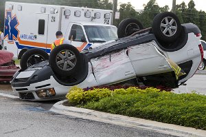 Overturned car with an ambulance in the background 1