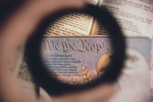 magnifying glass looking at the phrase "we the people"