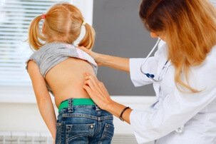 doctor looking at childs back