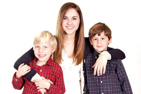 Teenage girl hugging two young boys