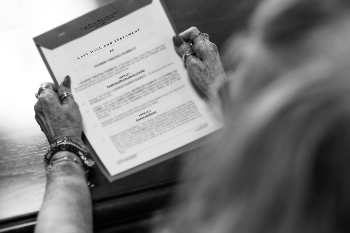 An elderly women holding documents