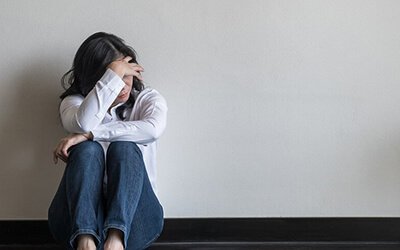 Woman sitting on the floor with head in hands