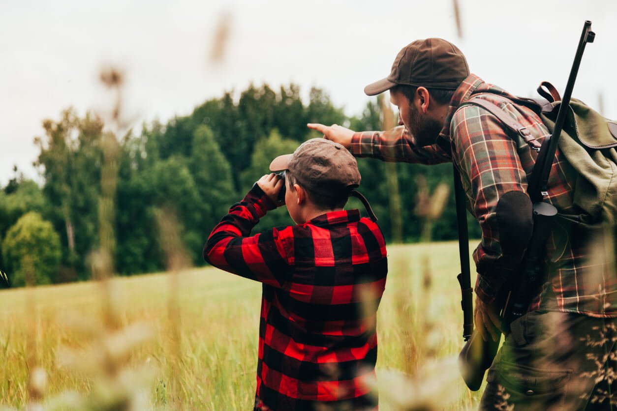 Father helping son hunt in the woods.jpg