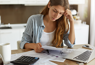 Indoor shot of casually dressed young woman holding papers in her hands