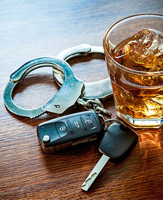 A whiskey glass, handcuffs, and car keys rest on a table (Bottom PA sized)
