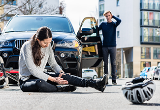 Young Female Bicyclist Fallen Down on Street After Traffic Accident