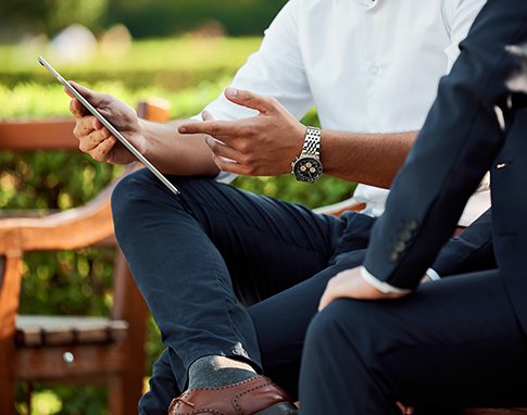 Two businessmen meeting on a park bench