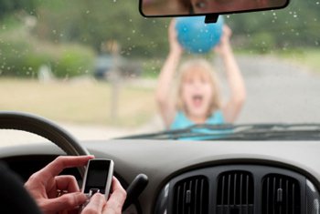 Texting driver about to hit a kid with a ball