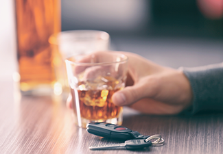 Man Sitting in Bar with Alcoholic Beverage and Car Key