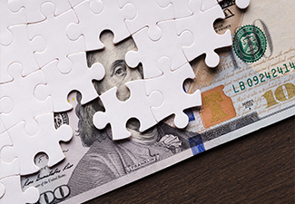 American dollar hidden under puzzle pieces