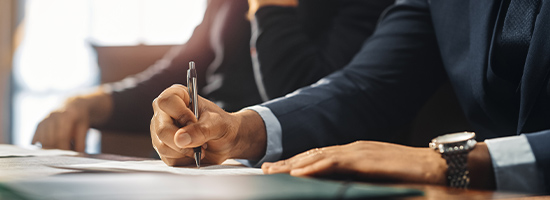 Two people sitting at desk writing on papers