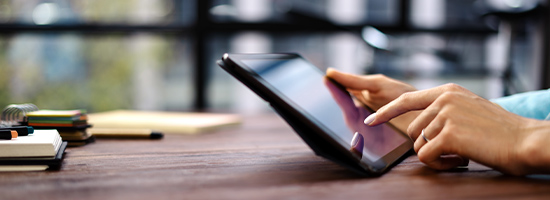 Person using a tablet at a desk