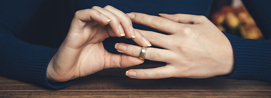 Woman taking wedding ring off her finger