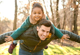 Young Man Playing with Little Girl Outdoors