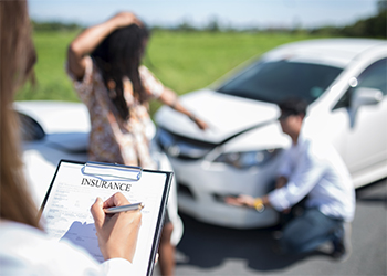  insurance agent examining car after accident