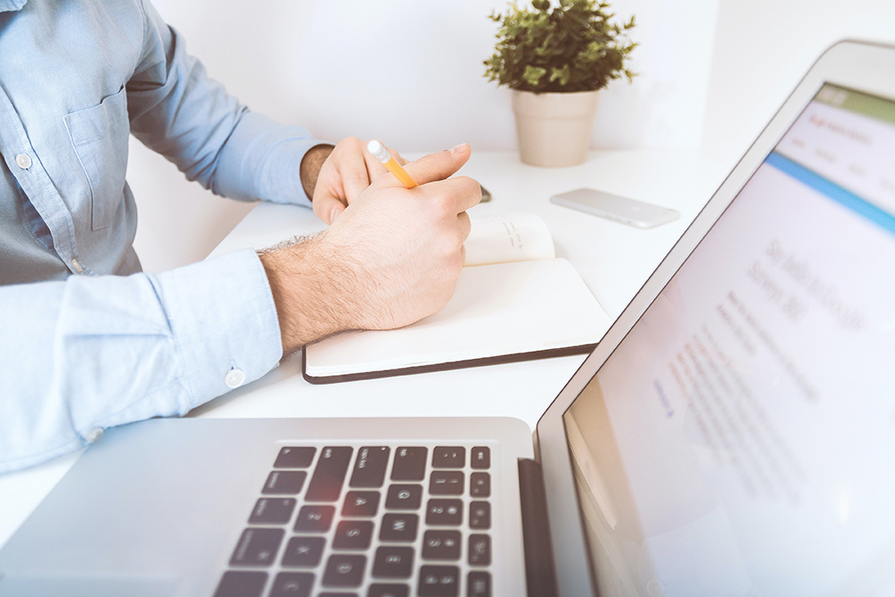 Man signing documents at computer