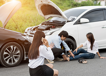 Stressed Driver Sitting At Roadside After Traffic Accident