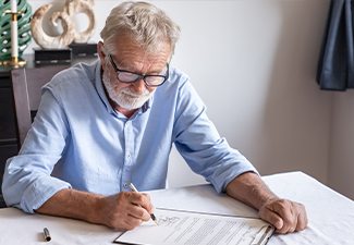 Man Elderly Examining and Signing Last Will and Testament