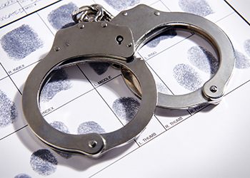 Handcuffs laying on top of fingerprint chart