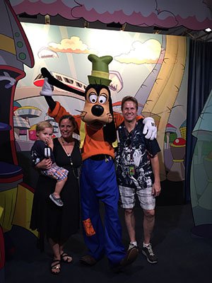 Attorney J. Jason Bangos with his Wife and Baby Standing by Goofy Cartoon Character