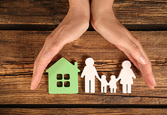 Woman Holding Hands Near Figures of House and Family