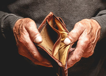 Empty wallet in the hands of an elderly man