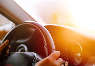 Close up of driver hands driving in road trip